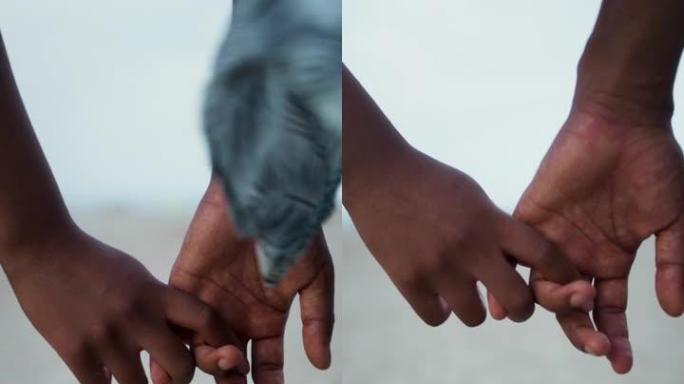 亲密亲密的非洲族裔夫妇牵手。海滩上的浪漫漫步垂直视频
