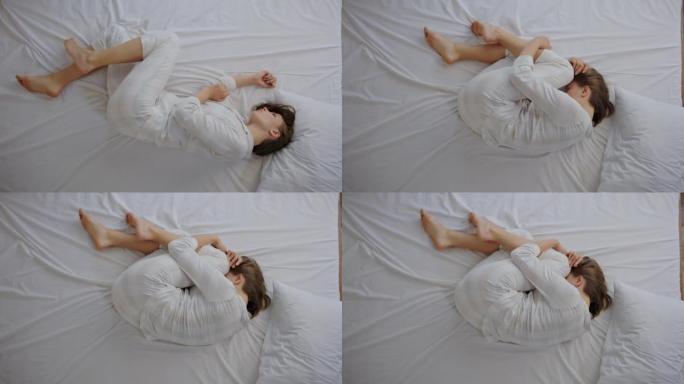 女人在床上curl缩在球上感到失望
