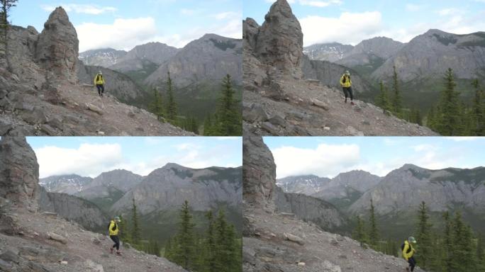 女越野跑运动员沿着山坡上的岩石路线行驶