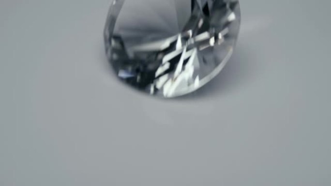 一个大而漂亮的钻石在白色 (黑色) 表面上滑动