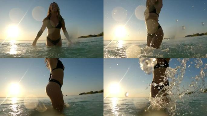 美丽的女人在热带水中享受日落