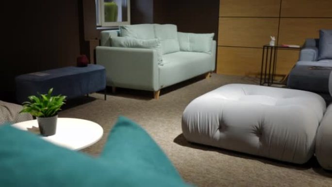 用舒适的柔软沙发在家具沙龙中左右平移。宽镜头现代豪华昂贵舒适沙发出售，室内无人。慢动作。