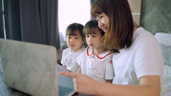 社交电话会议，亚洲女儿和单身母亲通过带有无线互联网系统的计算机上在线课程。