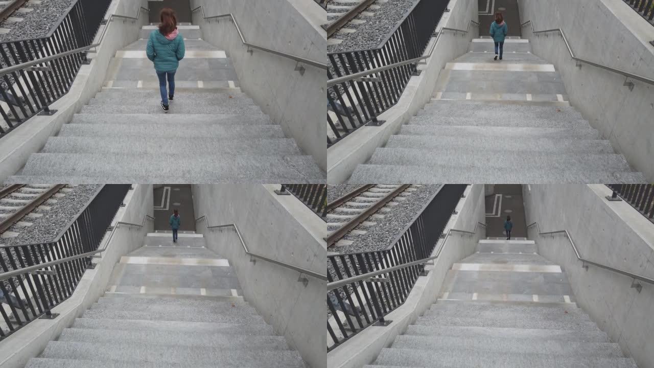 年轻女孩在火车站的台阶上行走