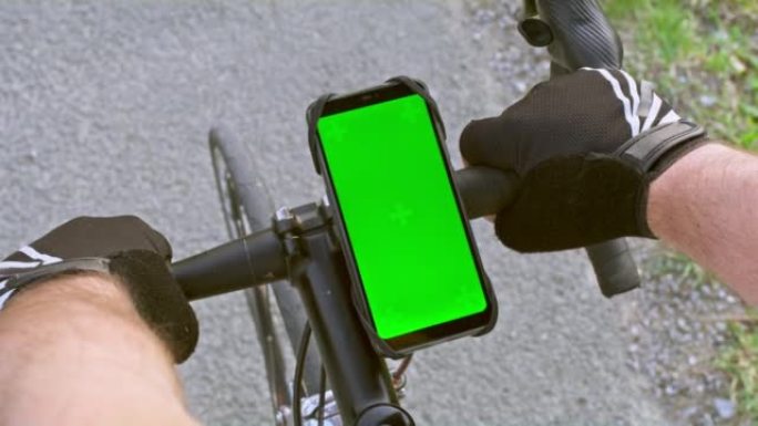男性手按下设置在公路自行车上的智能手机的屏幕