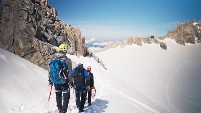 一队登山者沿着陡峭的山峰移动。冬季景观