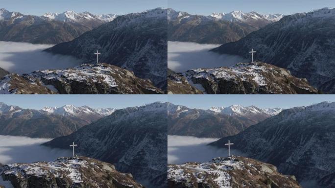空中无人机在被山脉包围的山顶上拍摄十字架