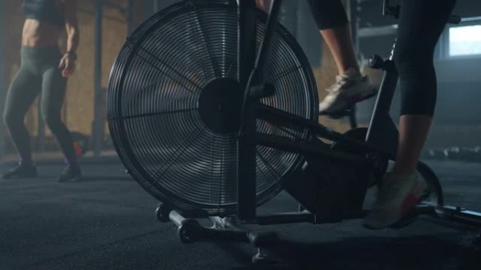 在现代健身中心内，女人正在健身房旋转固定自行车的踏板，特写镜头