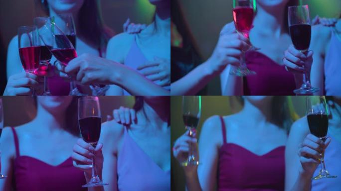 女性朋友手持一杯香槟在夜总会跳舞