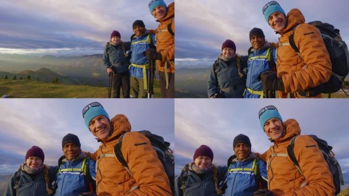 SLO MO三个徒步旅行者在日落时在山顶上摆姿势