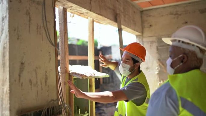 建筑工人在建筑工地检查用电-戴着防护口罩