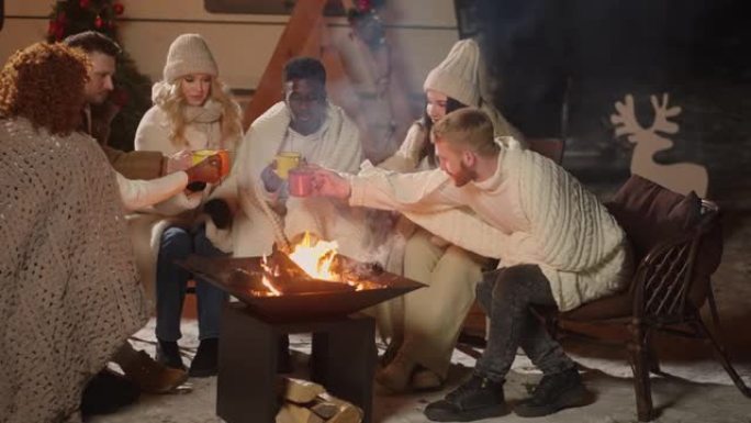 圣诞节，一群朋友在乡下的房子里休息，围坐在篝火旁，喝热酒