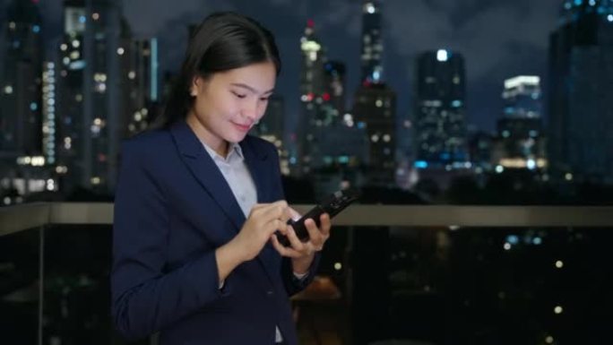 亚洲女商人在办公室的阳台上使用移动互联网。
