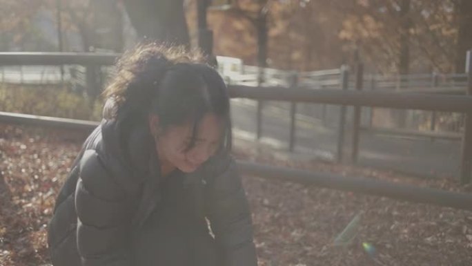 女士慢动作旺盛的年轻女子在韩国首尔秋天将金色的秋叶扔在头顶