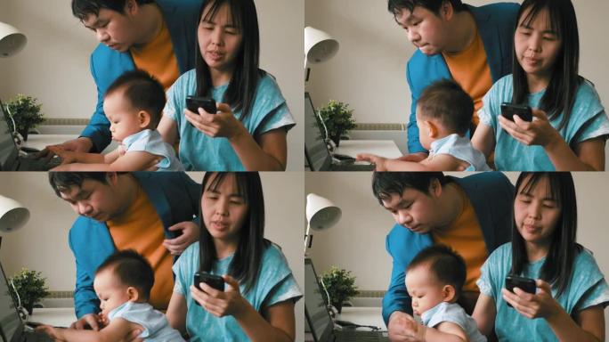 亚洲家庭与男婴使用笔记本电脑在家工作