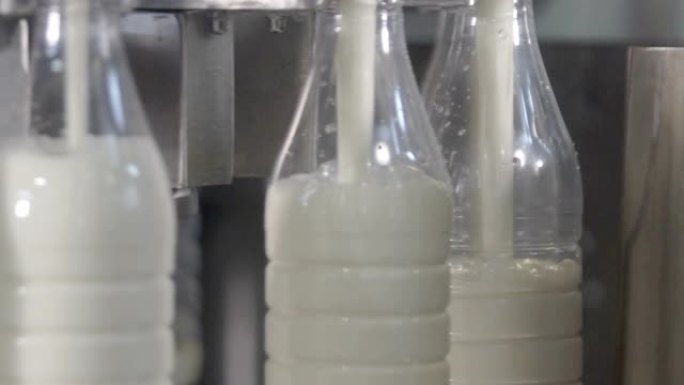 牛奶倒入食品厂的塑料瓶中。慢动作