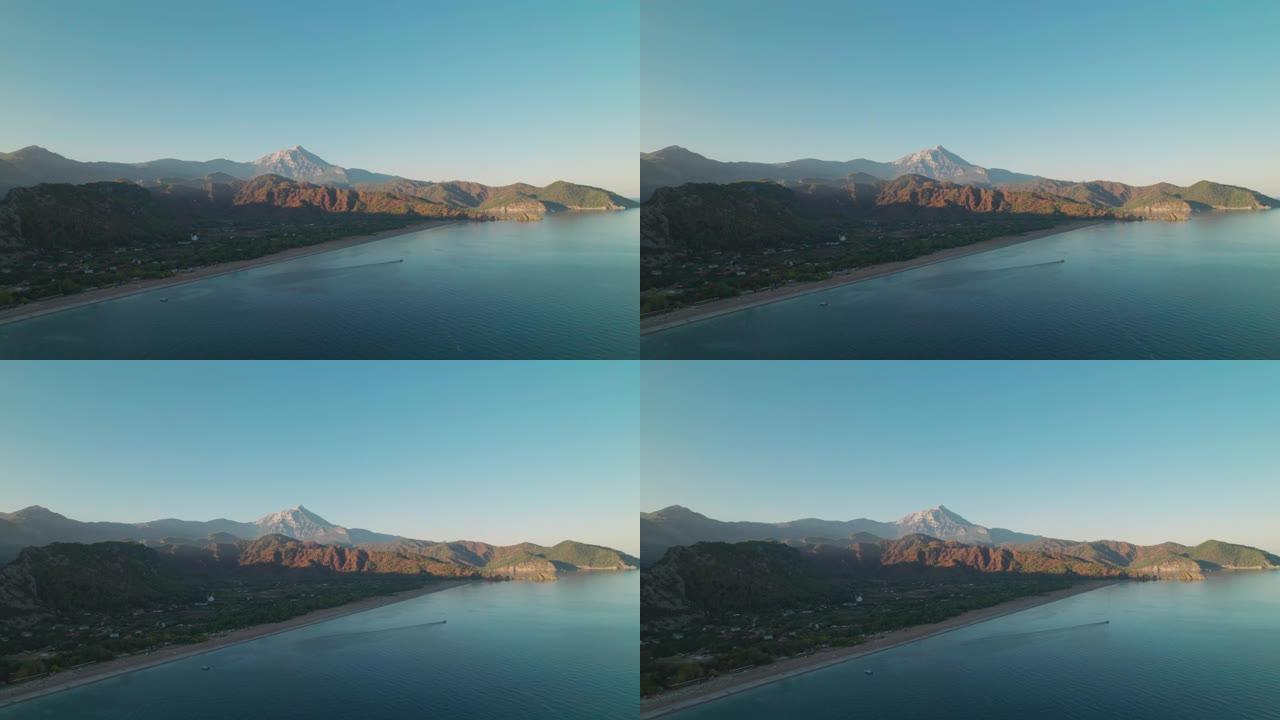 在日落时对海洋海岸附近的山脉进行空中无人机拍摄