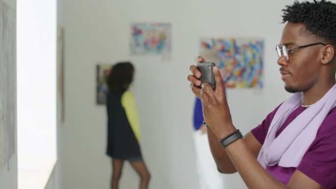 黑人在画廊拍摄绘画照片