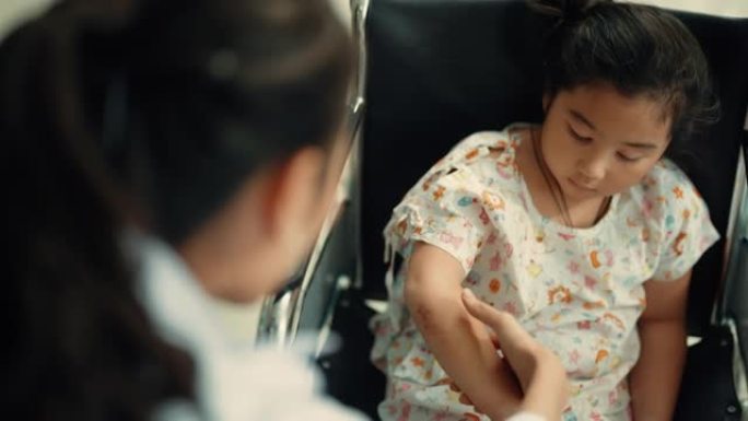 小女孩坐在轮椅上，与骨科医生交谈。