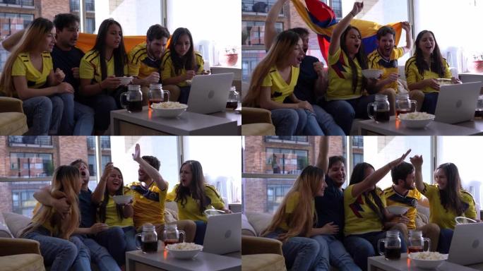 一群兴奋的朋友在家里用笔记本电脑观看足球比赛时庆祝比分