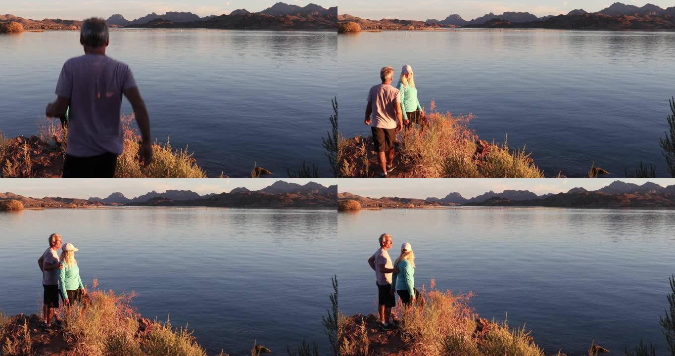 夫妇在日出时从湖岸线上欣赏风景