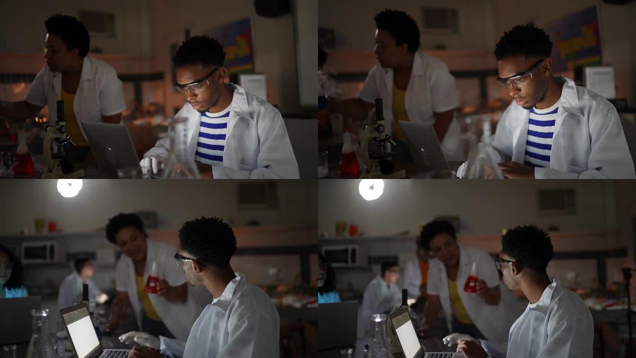 老师在实验室使用笔记本电脑与学生交谈