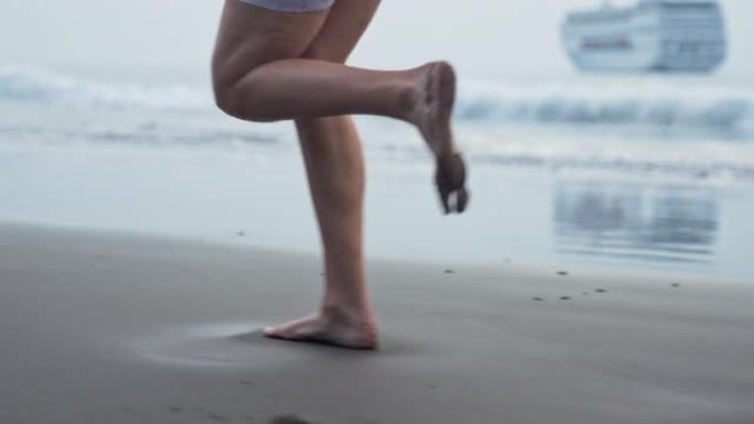 海滨慢跑训练。享受阳光和自由的女人。赤脚在湿沙上奔跑