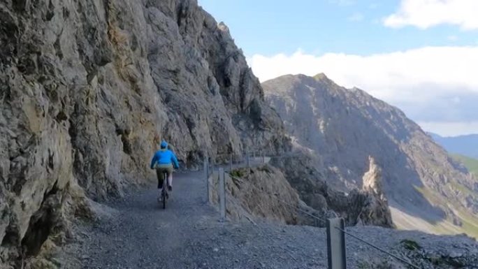女子山地自行车沿着岩石小路的第一人称视角