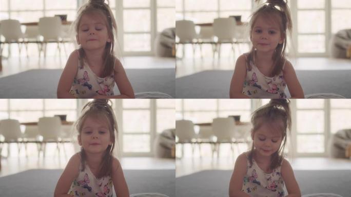 可爱的小女孩对着镜头跳舞微笑。家庭内部