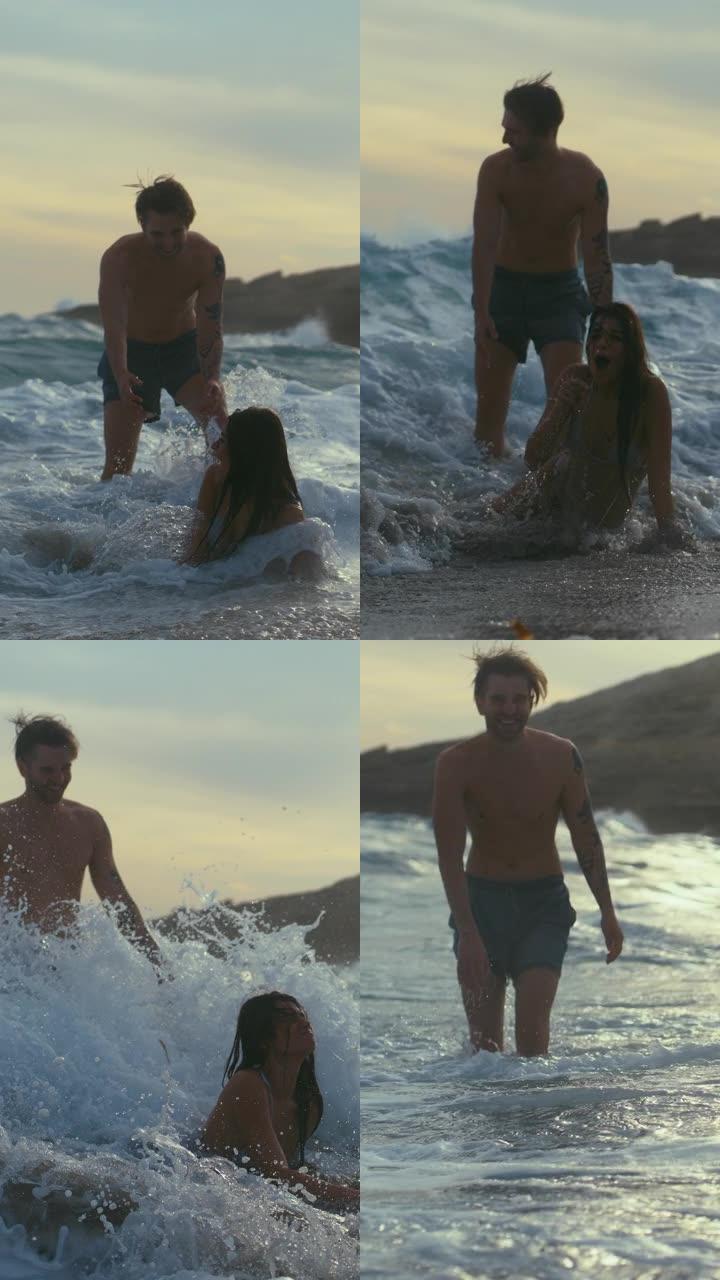 海滩上的浪漫情侣。在海浪中播放垂直视频