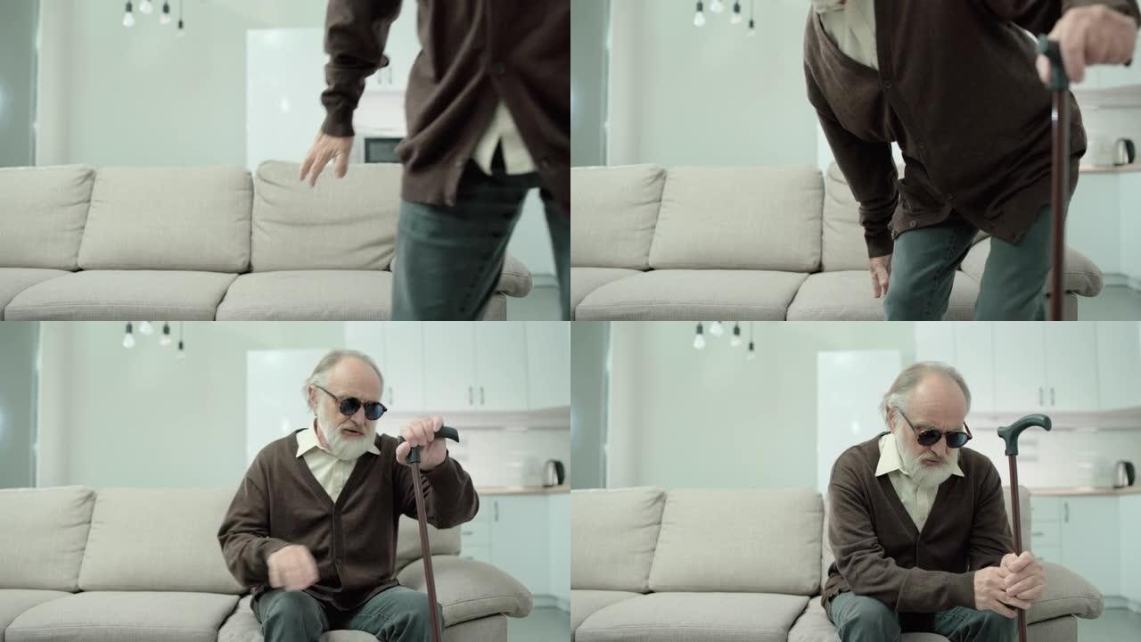 盲人老人，手杖坐在沙发上，视力丧失，问题