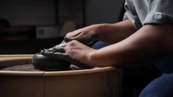匿名人士在陶艺工作室使用陶轮和雕刻粘土。年轻人为产品铸造粘土。教育、商业、艺术天赋和创意手工制作的概