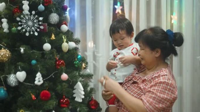 女人和孙子钦佩地看着圣诞树。