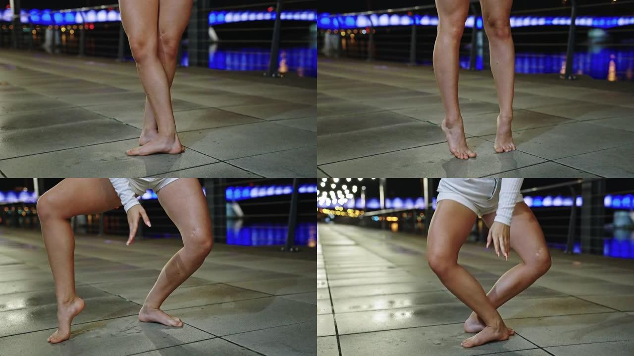 年轻女子在潮湿的城市街道上表演自由式舞蹈。专注于腿