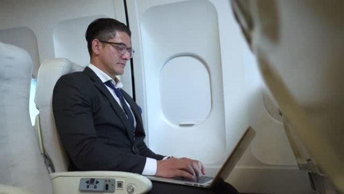 商人在飞行中使用笔记本电脑