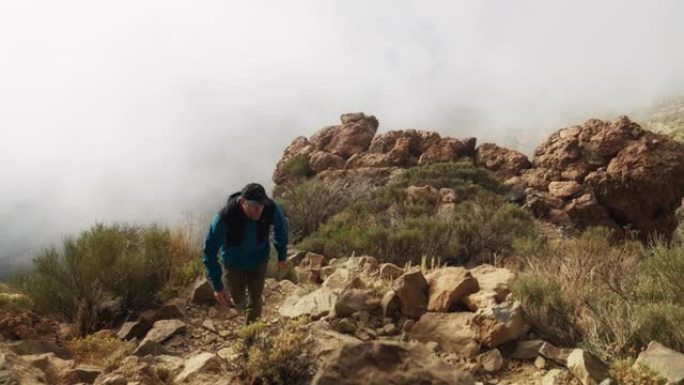 人走在山上的一条小路上。火山景观