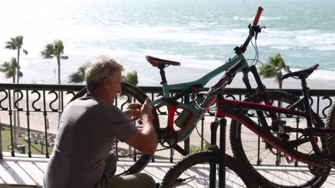 男子在海滨露台上修理自行车