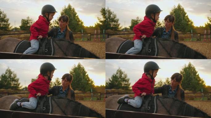 小男孩正在小马俱乐部学习骑马，女子骑马教练正在教蹒跚学步的孩子