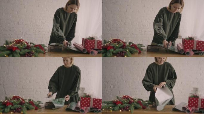 肖像一名年轻女子用花环在木桌上装饰礼物，翻过来放在桌子上，一个用丝带压碎的现成的圣诞盒