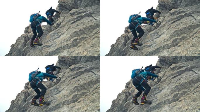 一队登山者在欧洲阿尔卑斯山的陡峭山峰上移动。使用绳索和攀爬设备