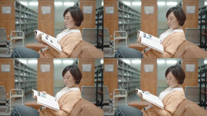 亚洲妇女在图书馆的书架上看书