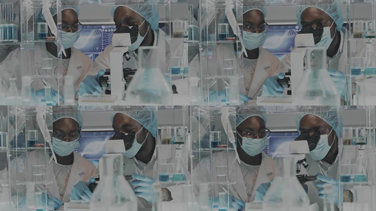 从事显微镜工作的非洲族裔科学家。浏览实验室玻璃器皿