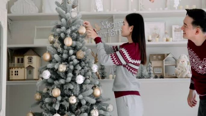 亚洲男女夫妇在节日期间通过家庭装饰庆祝圣诞节。