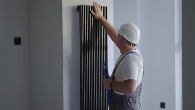 供暖季节开始后，水管工检查房屋中装饰电池的温度。