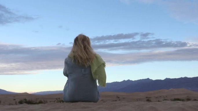女人在沙漠中的沙丘上放松
