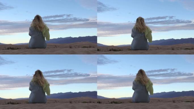 女人在沙漠中的沙丘上放松