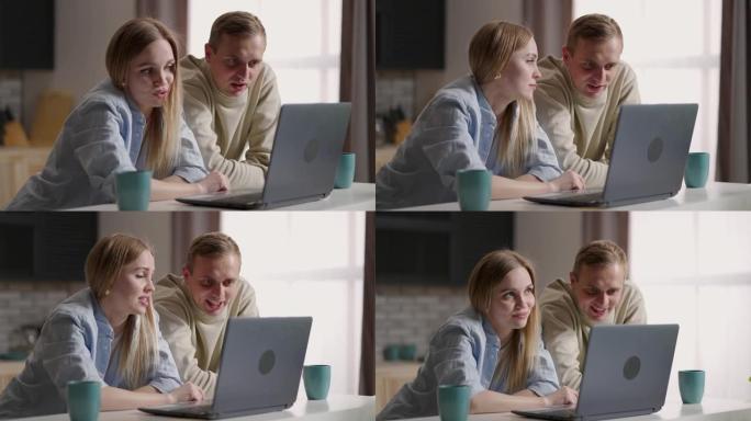 已婚夫妇坐在厨房里，使用互联网和笔记本电脑设备进行视频通话。远程交流，与家人愉快的视频会议对话。现代