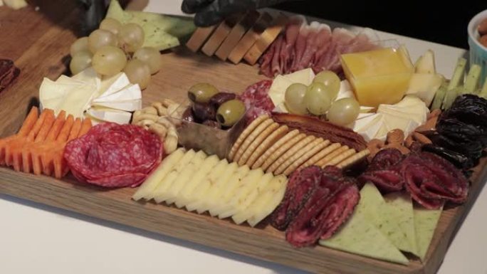开胃菜板，配有各种奶酪、肉、葡萄和坚果。熟食和奶酪拼盘。
