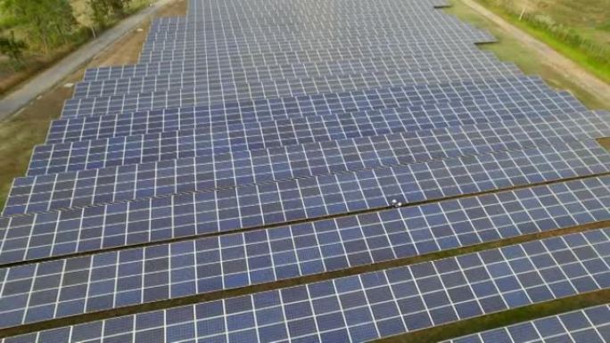 从阳光下鸟瞰太阳能电池的技术工程师，检查太阳能发电场的太阳能电池板。
