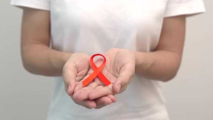 手握橙色丝带为白血病，肾癌日，世界多发性硬化症，CRPS，自我伤害意识月。医疗保健和单词癌症日概念